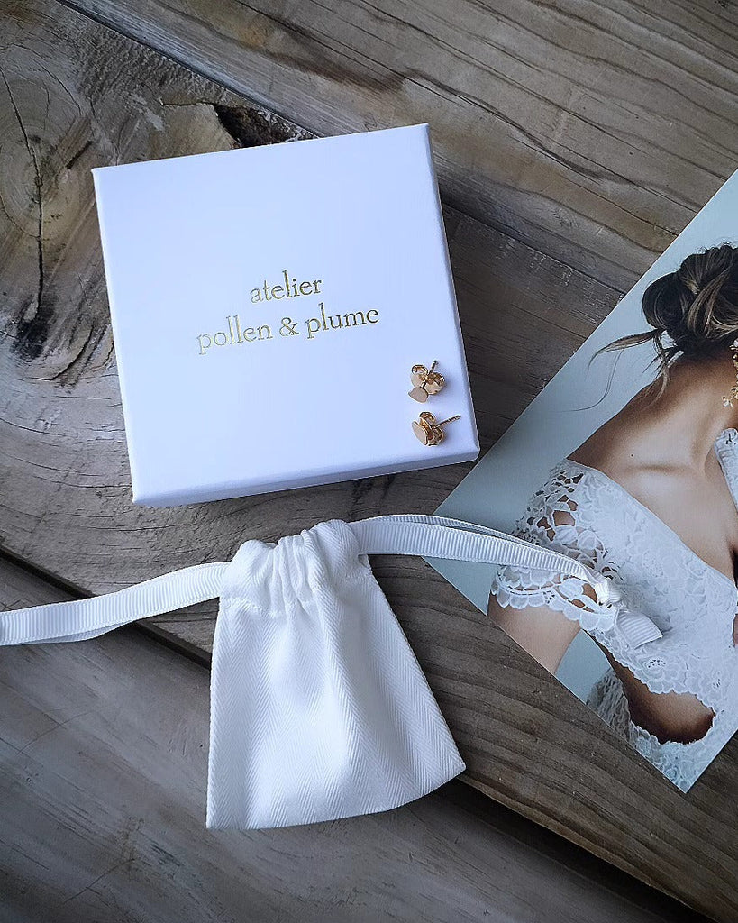 Jewelry set with 'atelier pollen & plume' box on a wooden surface