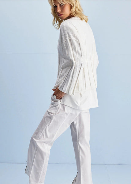 Person wearing a white outfit against a light blue background