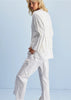 Person wearing a white outfit against a light blue background